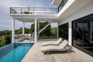 a villa with a swimming pool and a house at Sunset villa rooftop with pool 180 Seaview in Koh Phangan