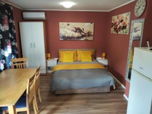 a bedroom with a bed with yellow pillows and a table at City Break Apartment in Zagreb