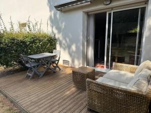 a wooden deck with a table and chairs on it at ღ Le Prieuré - Terrasse, Parking, Jardin et Wi-Fi in La Rochelle