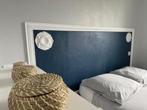 a bedroom with a bed and a blue wall at ღ Le Prieuré - Terrasse, Parking, Jardin et Wi-Fi in La Rochelle
