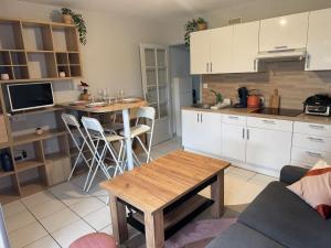 a kitchen with white cabinets and a table in a room at ღ Le Prieuré - Terrasse, Parking, Jardin et Wi-Fi in La Rochelle