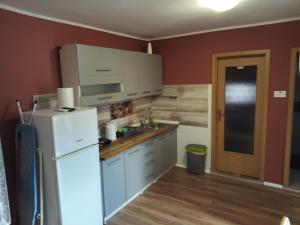 a kitchen with white cabinets and a white refrigerator at City Break Apartment in Zagreb