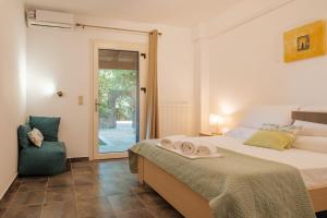 a bedroom with a bed and a chair and a window at Kompitsi View Retreat in Kompítsion