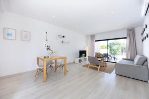 een witte woonkamer met een tafel en een bank bij Villa Jump Jibe in Sagres +20 foto's