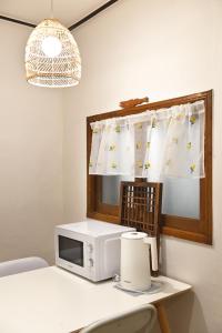 a microwave sitting on a table with a window at 가나다스테이 GaNaDaStay ,Busan, Gwangalli-Beach #광안역 6번출구 8분거리#광안해수욕장 15분 #단체8인숙소 in Busan