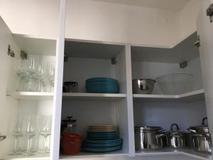 a white cabinet filled with glasses and plates at Vista Monte Baldo in Toscolano Maderno