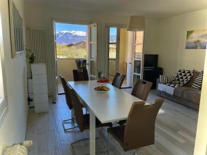 a dining room with a table and chairs and a living room at Vista Monte Baldo in Toscolano Maderno