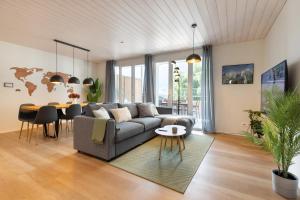 a living room with a couch and a table at Scenic Holiday Apartment with Balcony Views in Lungern