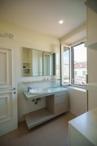 ein weißes Badezimmer mit Waschbecken und Fenster in der Unterkunft Anguillara in the Heart of Florence in Florenz