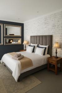 une chambre avec un grand lit blanc avec un miroir dans l'établissement Limonite GuestHouse, à Pretoria 24 autres photos