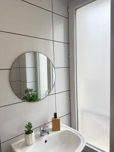 a bathroom with a sink and a mirror at Studio Rosa - Disney - Meaux City Center - Paris in Meaux