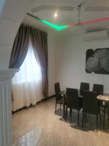 a dining room with a table and chairs and a window at Eno Mary s home in North Legon