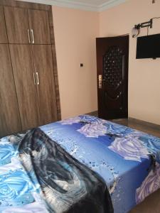 a bedroom with a blue bed and wooden cabinets at Eno Mary s home in North Legon +6 photos