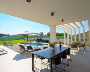 TerzignoにあるLa Dolce Vita Villa with Sauna & Private Poolのテーブルと椅子とプールのあるパティオ +21枚の写真