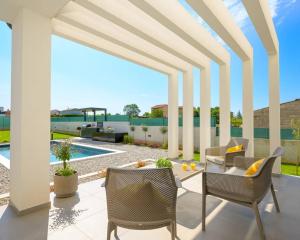 TerzignoにあるLa Dolce Vita Villa with Sauna & Private Poolのパティオ(椅子、テーブル、プール付)