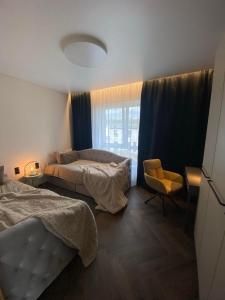 a bedroom with two beds and a chair and a window at Two Bedroom Riverland Apartment in VNO