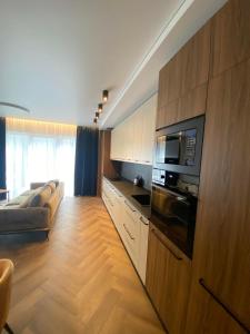 a large kitchen with a couch and a microwave at Two Bedroom Riverland Apartment in VNO