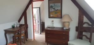 a room with a dresser and a desk with a lamp at La Chouetterie in Binic