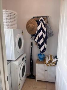 a laundry room with a washing machine and a washer at Pet friendly beach cottage in Victoria in Paradise Beach