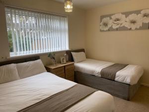 Un dormitorio con dos camas y una ventana. en Durham Stay 2BR, en Durham