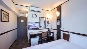 une chambre d'hôtel avec un bureau et un lit dans l'établissement Toyoko Inn Maibara eki Shinkansen Nishi guchi, à Maibara