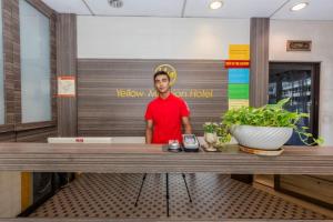 マラッカにあるHotel Q Banda Kaba Near Red Buldingの店内のテーブルの後ろに立っている男性