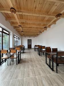 an empty room with wooden tables and chairs at Tabylga guest house in Jalal-Abad