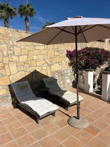 an umbrella and two lounge chairs and a table at La Ladera Bay View in La Herradura