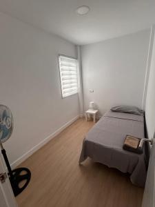 - une chambre avec un lit et une fenêtre avec un ventilateur dans l'établissement Padre Anchieta 35 - 8, à Santa Cruz de Tenerife 1 autre photo
