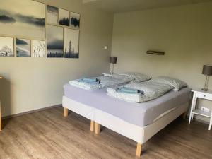 two beds in a room with paintings on the wall at Ferienhaus an der Ostsee mit großem Garten in Rerik