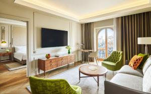 a living room with a couch and a tv at InterContinental Athenee Palace Bucharest by IHG in Bucharest