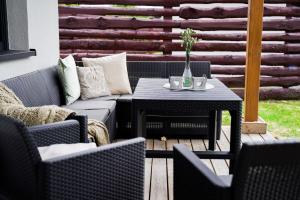 een patio met een bank en een tafel met stoelen bij Domki Natura Zator in Graboszyce
