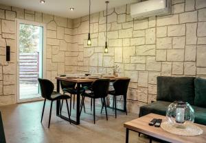 een eetkamer met een tafel en stoelen en een stenen muur bij Domki Natura Zator in Graboszyce