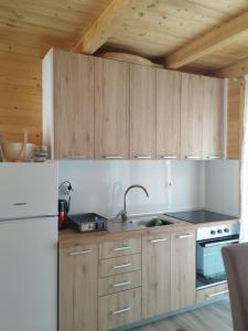 a kitchen with wooden cabinets and a white refrigerator at Pax Montana in Blidinje