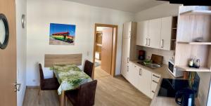 a small kitchen with a table and a dining room at Ferienwohnung für Alt und Jung in Sonneberg
