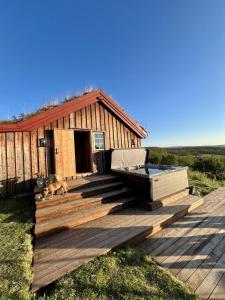 a deck with a hot tub and a dog in front of a house at Geilo - Charming cottage with a stunning view in Geilo