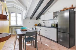 eine Küche mit Tisch und Edelstahlkühlschrank in der Unterkunft Mema Holiday Home in Aosta + 17 Fotos