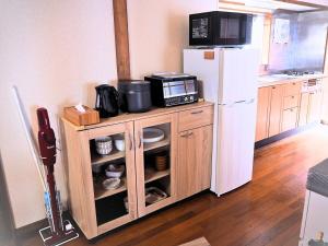 a kitchen with a microwave and a refrigerator at 天宿りAmayadori in Ise