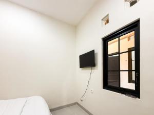 a white room with a window and a tv at Urbanview Hotel Simple near Pakuwon Mall Jogja in Seturan