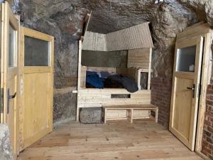 a room with a bed in a stone wall at Jeskyne Janska in Janská