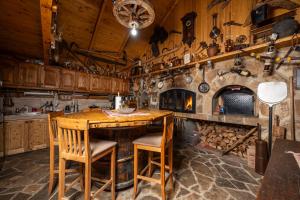 a kitchen with a wooden table and a fireplace at Seosko domacinstvo Jahova voda - Muratovići in Petnjica