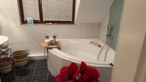 a bathroom with a white tub and a red flower at Gabriel in Sankt Augustin