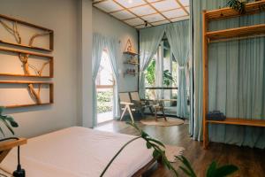 a bedroom with a bed and a room with a window at TỊNH Retreat Phu Quoc in Phú Quốc +33 photos