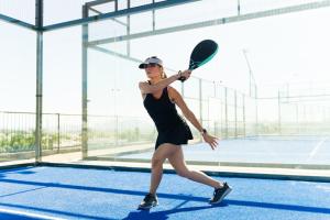 a woman holding a tennis racket on a tennis court at Setclub Hôtel & Spa Aix-en-Provence in Aix-en-Provence +77 photos