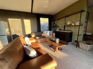 a living room with a leather couch and a table at Skye Ridge in Calitzdorp