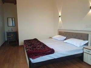 Un dormitorio con una cama grande con dos almohadas. en Panchavati Hills Homestay, en Dwārāhāt
