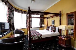 a bedroom with a canopy bed and a chair at The Imperial Hotel in Fort William