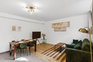 a living room with a green couch and a table at Terra & Verde Stay in Starnberg