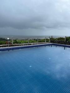 a large blue swimming pool with the ocean in the background at Villa Arionne in Borlai