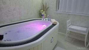 a bathroom with a tub with a purple dye at Harmony Retreat in Dealu Negru